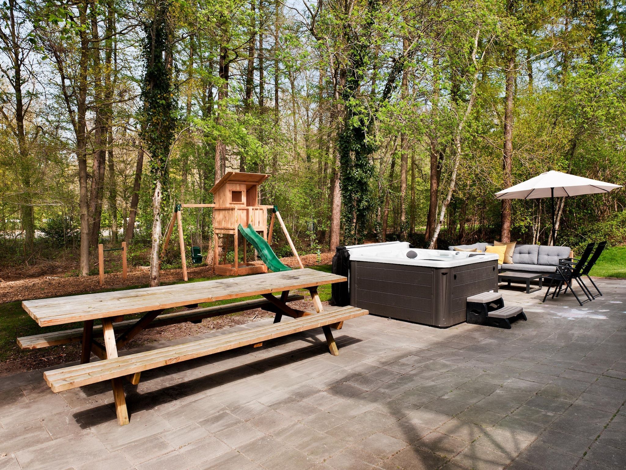 Het terras van 20 pers groot Abeltjeshuis Wellness de luxe met buitenspa in Vlagtwedde