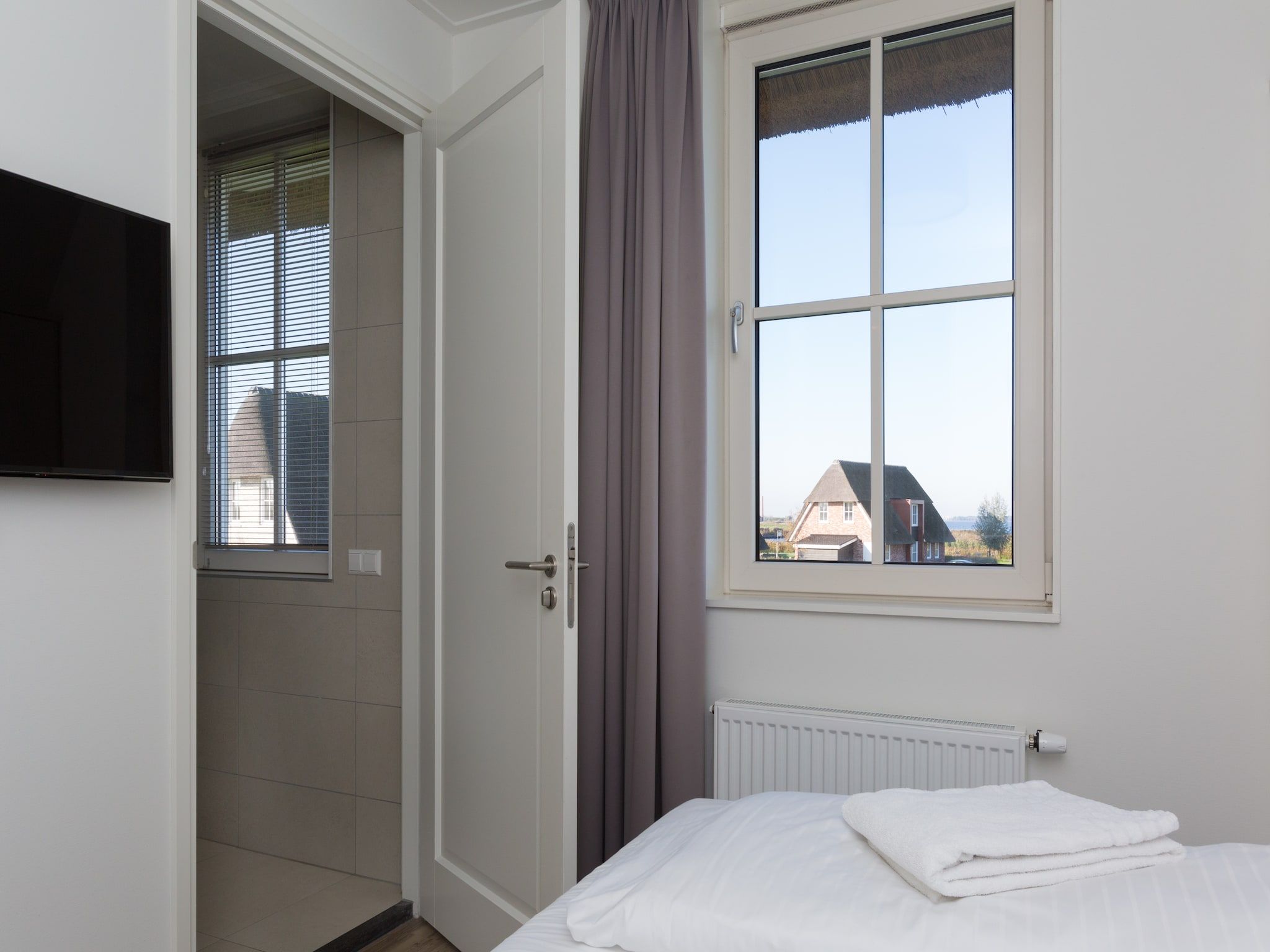 Een slaapkamer van Friese Meren Villa's 14 in Delfstrahuizen